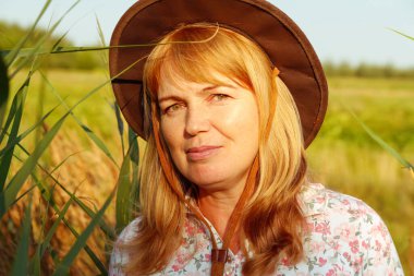 Defocus, doğa arka planında güzel sarışın bir kadının dış portresini yakından çek. Sanat gölgeleri ekin. Meadow 'daki kovboy kız. Akıl sağlığı, sessizlik. Kırsal kesimde, sağlıkta. Odaklanamıyorum.