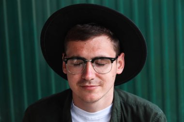 İnsan, uyum, psikoloji. Mutlu akıllı adam. Yakışıklı, gülümseyen stil sahibi hipster Lambersex modelinin portresi. Gözlüklü ve siyah şapkalı bir adam. Modern arka planda bir erkek. Yakışıklı portre..