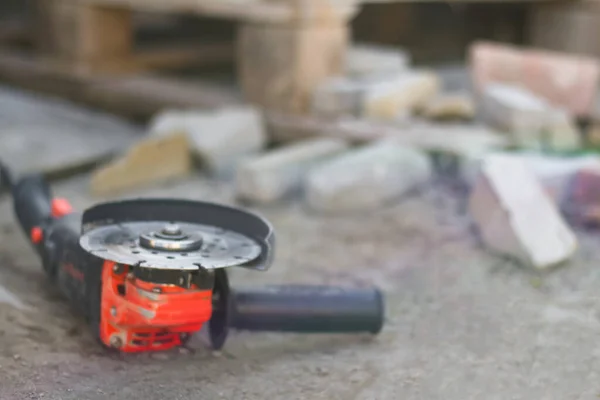 Defocus angle grinder. Tool for construction industry. Copy space. Construction design backdrop. Blurred grinder. Orange flare. Grinding. Improvement home. DIY. Work tool. Circular. Out of focus.