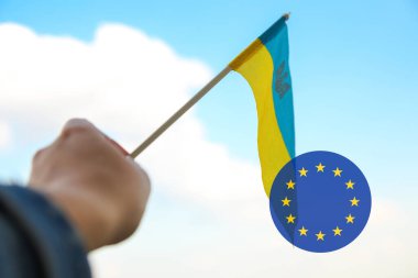 Avrupa Birliği ve Ukrayna 'nın dikkatini dağıt. Mavi gökyüzünde dalgalanan büyük ulusal sembol. Ukrayna 'yı destekle ve yardım et, Bağımsızlık Anayasa Günü, Ulusal Bayram. El ele tutuşan bayrak. Birlik. Odaklanamıyorum.
