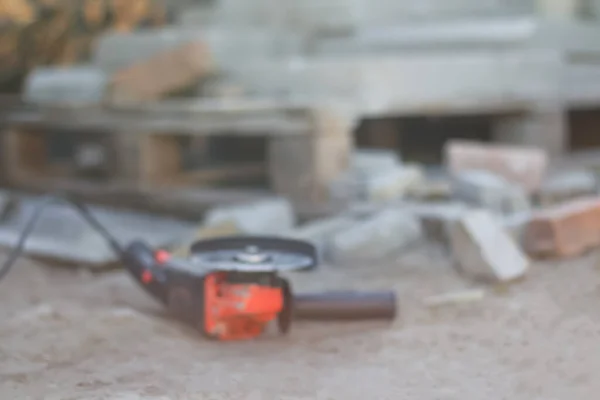 Defocus angle grinder. Tool for construction industry. Copy space. Construction design backdrop. Blurred grinder. Orange flare. Improvement home. Out of focus.