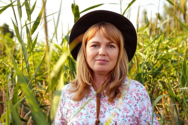 Defocus, doğa arka planında güzel sarışın bir kadının dış portresini yakından çek. Sanat gölgeleri ekin. Meadow 'daki kovboy kız. Akıl sağlığı, sessizlik. Yaşam tarzı, sağlık, boho. Odaklanamıyorum.