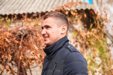 Sonbahar sonbahar delikanlısı Defocus. Sakin adam sonbahar parkında rahatlıyor ve derin nefes alıyor. Genç adam gülümsüyor, kalın elbiseler giyiyor. Odaklanamıyorum.