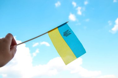 Defocus Ukraine flag. Large national symbol fluttering in blue sky. Support and help Ukraine, Independence Constitution Day, National holiday. Hand holding flag. Save Mariupol. Out of focus.