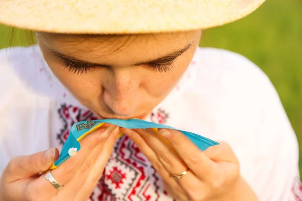 Defocus young ukrainian woman portrait. Meadow nature background. Kissing ukrainian flag. Smiling ukrainian girl showing feeling love. Vyshyvanka. Proud to be ukrainian. Out of focus.