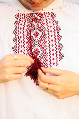 Defocus emboidery Ukrayna desenli arka plan. Ukrayna süsü. Kıyafetlere işlenmiş süsler. Beyaz arka planda işlenmiş Ukrayna. Vyshyvanka 'daki kadın. Yakın plan. Odaklanamıyorum.