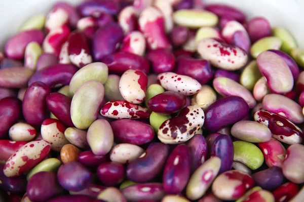 Defocus purple beans background. Background of many grains of dried beans. Brown beans texture. Food background. Brazilian diet snack food. Red kidney bean. Out of focus.