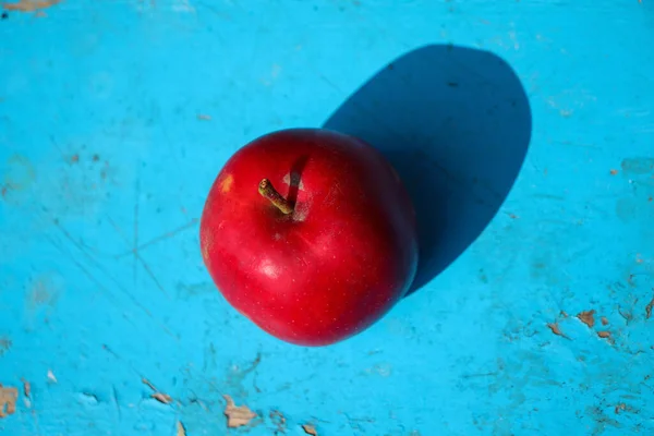 Defocus red apple on blue background. One ripe juicy red fresh tomato. Farm vegetables natural eco bio. Minimalism trendy background. Top view. minimalism pattern poster. Modern food Out of focus.