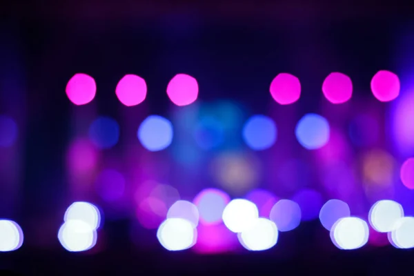 Defocus blurred abstract purple bokeh background. Festive spotted glitter background. Blurry music performance in rock band concert. Light holiday. Out of focus.