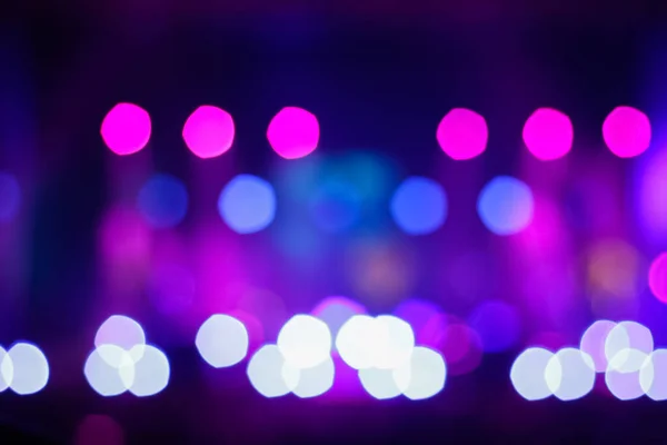 Defocus blurred abstract purple bokeh background. Festive spotted glitter background. Blurry music performance in rock band concert. Out of focus.