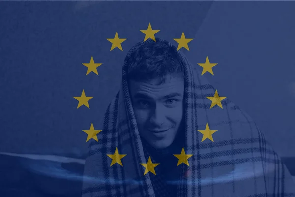 Defocus man wearing blanket. Flag European Union. Increase in the cost of gas bill. Soaring energy prices. Increase in the price of natural gas. Price. Energy crisis in Europe. Out of focus.