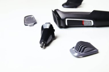 Beyaz zemin üzerinde farklı bir set olan defocus elektrikli kırpıcı. Beyaz arka planda izole edilmiş profesyonel bir saç makasıydı. Elektrikli siyah saç makasının yan görüntüsü, yakın plan. Sakal. Odaklanamıyorum.