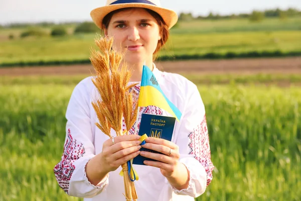 若いウクライナ人女性の肖像画に焦点を当てる 牧草地の自然を背景にタイ小麦の熟した黄金の小花の花束 旗ウクライナを示す ウクライナ人の女の子を笑顔 集中できない — ストック写真