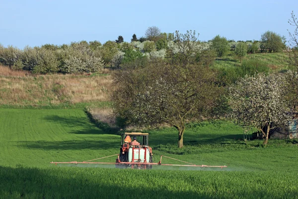 在种植前喷涂领域的农用拖拉机 — 图库照片