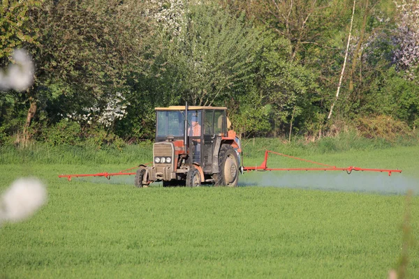 Zemědělský traktor postřik pole před výsadbou — Stock fotografie