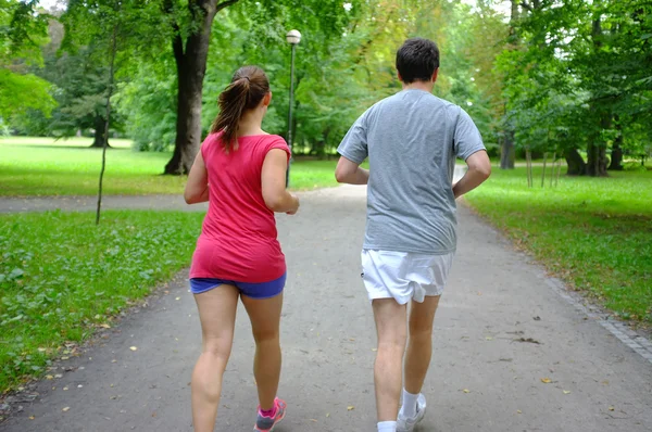 Caucasian couple jogging in summer park. — Stock Photo, Image