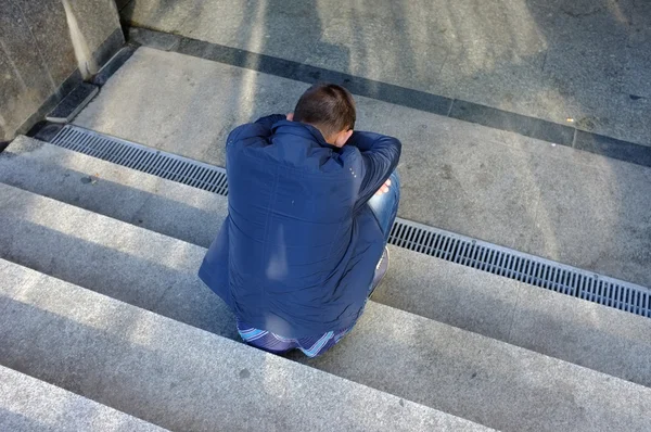 Homem solitário sentado nas escadas — Fotografia de Stock