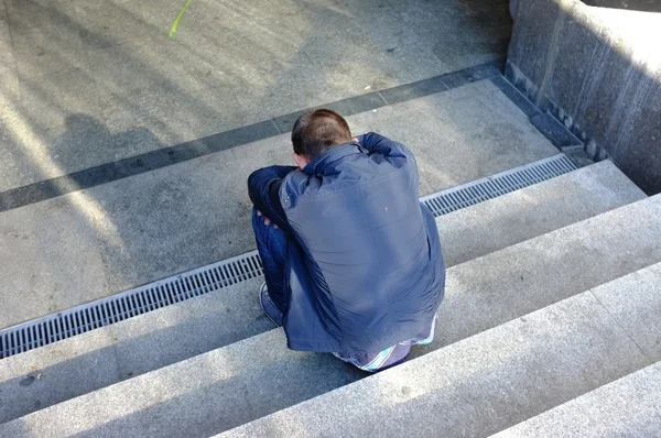 Samotny mężczyzna siedzący na schodach — Zdjęcie stockowe