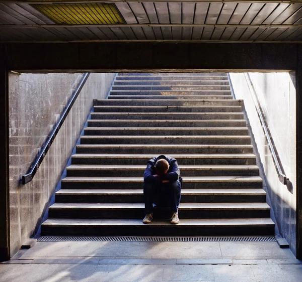 계단에 앉아 외로운 남자 스톡 사진