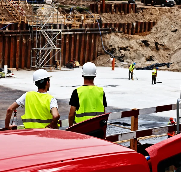 Byggnadsarbetare diskuterar planer — Stockfoto
