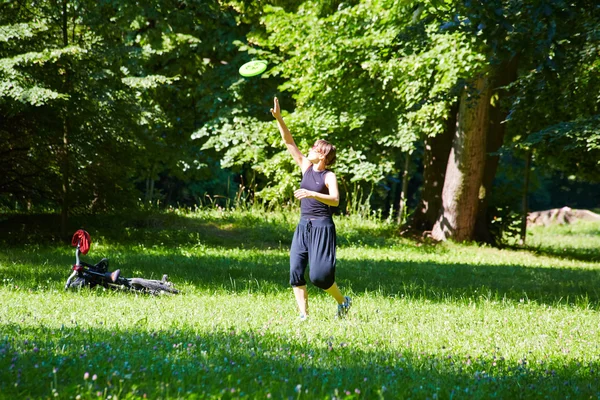 Mladá žena hrát frisbee — Stock fotografie