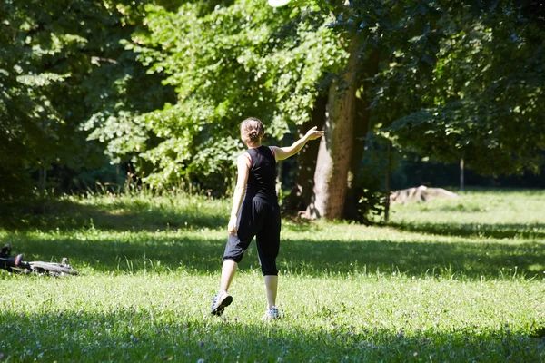 Joven mujer jugando frisbee — Foto de Stock