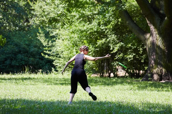 Giovane donna che gioca frisbee — Foto Stock