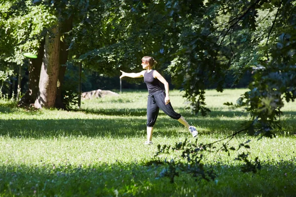 Jovem mulher jogando frisbee — Fotografia de Stock