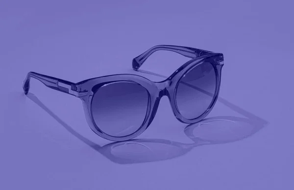 Wanita fashion berkacamata hitam dengan latar belakang ungu. Warna Trending — Stok Foto