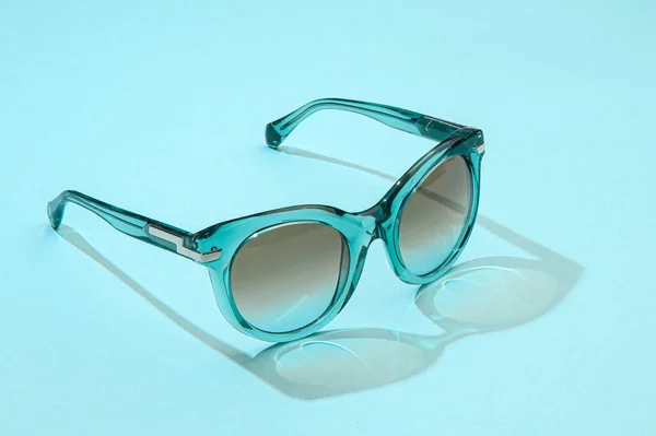 Gafas de sol de mujer de moda de verano sobre fondo azul pastel a la luz del sol. Modernas gafas de sol femeninas con estilo para unas hermosas vacaciones de vacaciones. Banner con espacio de copia para la exhibición de la venta de diseño o compras —  Fotos de Stock