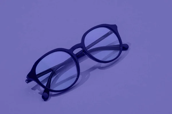 Glasögon i mode minimalt koncept. Glasögon med ny 2022 trendiga PANTONE 17-3938 Mycket Peri färg. Stockbild