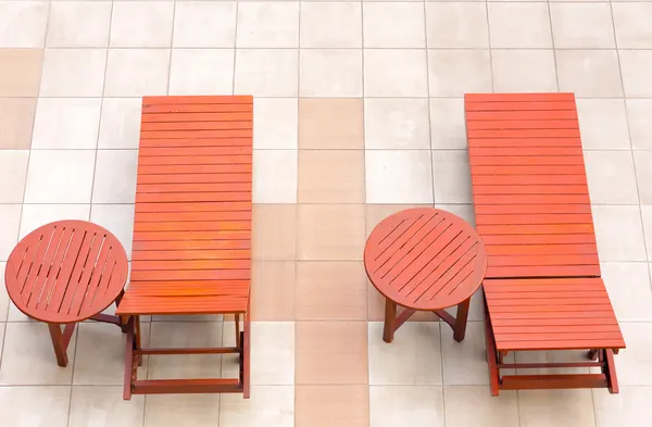 Chaises longues au bord de la piscine à côté de la piscine bleue vue de dessus — Photo