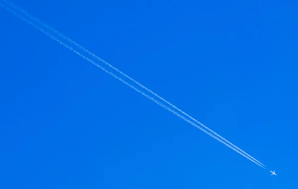 Стежка конденсації літака, що спускається на блакитному небі Ліцензійні Стокові Фото
