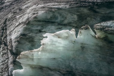 Buzul yüzeyinin minimalist arka planında çatlaklar ve çizikler var. Buzul duvarlarından oluşan minimum doğal zemin ve buzuldan gelen buz blokları yakın mesafede. Parlak buzul duvarının güzel doğa dokusu.