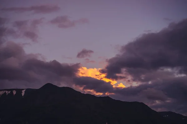 ライラックの夜明けの空と大気中の山の風景 紫の夕焼け空の下で雪の岩と風景 パステルトーンで山の中で美しい日の出 明け方の曇天のイルミネーション — ストック写真