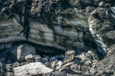 Buzul duvarının yanında çatlaklar ve çiziklerle buzul çağlayan doğa arka planı. Buzlu duvar ve buz blokları ile doğal zemin. Parlak buzul duvarı ve güneş ışığında buz blokları olan güzel bir manzara..