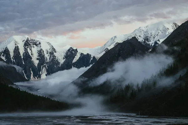 Malowniczy Krajobraz Wielkimi Zaśnieżonymi Górami Zachodzie Słońca Gęstymi Niskimi Chmurami — Zdjęcie stockowe