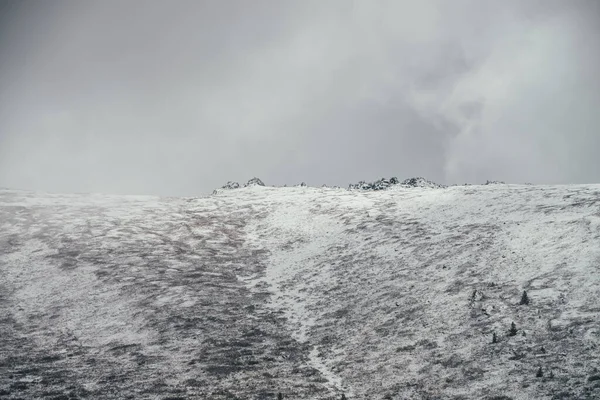 Minimalistyczny Zimowy Krajobraz Ostrymi Skałami Dużym Śnieżnym Szczycie Góry Pod — Zdjęcie stockowe