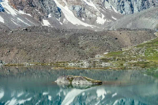 청록색 호수에 바위가 호수의 반사된 눈덮인 눈처럼 호수의 표면에 반사되는 — 스톡 사진