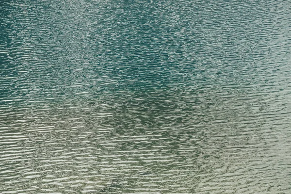 모양을 이루고 표면에는 명상적 물결이 자연은 황금빛으로 빛나는 호수의 배경이다 — 스톡 사진