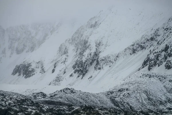 Mglisty Górski Krajobraz Białym Śniegiem Czarnych Skałach Pochmurną Pogodę Mglisty — Zdjęcie stockowe