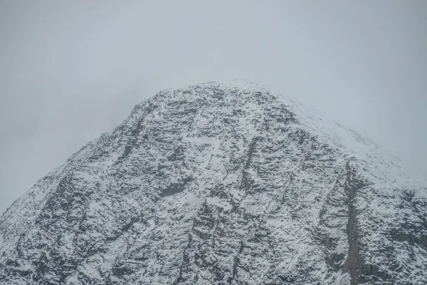 Mglisty Górski Krajobraz Białym Śniegiem Czarnych Skałach Pochmurnym Niebie Mglisty — Zdjęcie stockowe