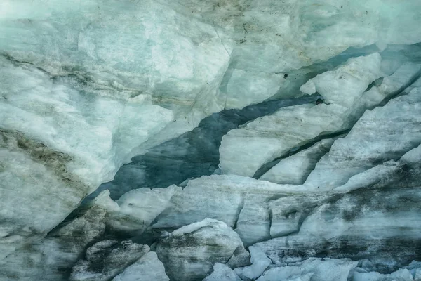Minimalist nature background of glacier surface with cracks and scratches close up. Minimal natural backdrop of icy wall and ice blocks. Shiny glacial surface. Beautiful nature texture of glacial wall