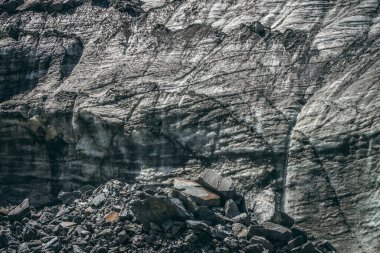 Buzulların yanında buzul çağlayanı ve çatlaklar ve çizikler olan doğa. Buzlu duvar ve morinalarla doğal zemin. Parlak buzullu duvarları ve güneş ışığında taşları olan güzel bir manzara. Buzul dokusu.
