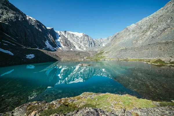 雪山映衬在冰湖清澈的水中 清澈的天空下 美丽的阳光普照 山湖水面上的冰川反射 岩石上的雪反映在高山湖中 — 图库照片