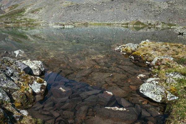 Cenário Bonito Ensolarado Com Gramíneas Rochas Perto Borda Água Lago — Fotografia de Stock
