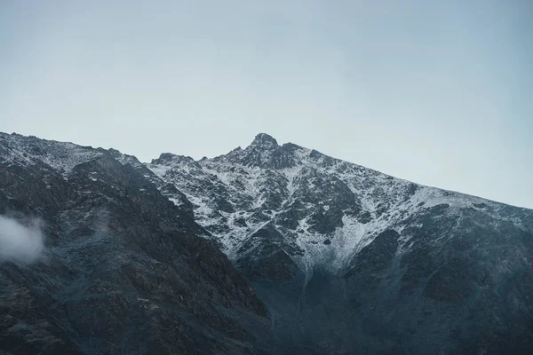 Bulutlu Gökyüzünde Karla Kaplı Yüksek Siyah Kayalık Dağ Tepeli Karanlık — Stok fotoğraf