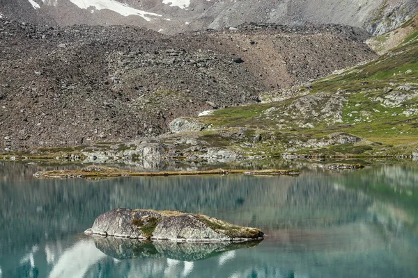 绿松石山湖中的岩石 雪山映衬在碧绿清澈的冰川湖水中 山湖绿水表面反射雪白冰川的美丽阳光背景 — 图库照片