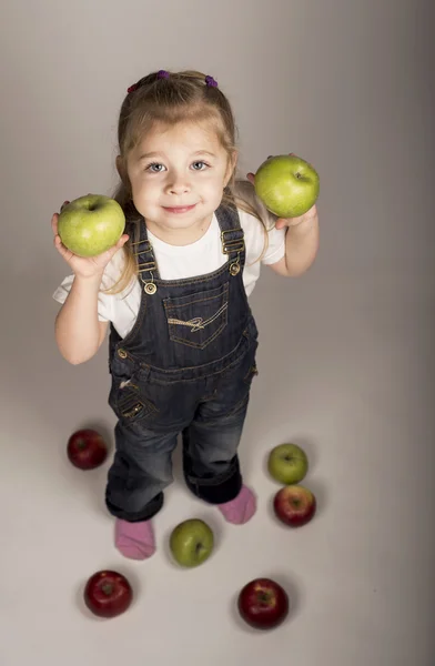 The little girl plays with apples — Stock Photo, Image