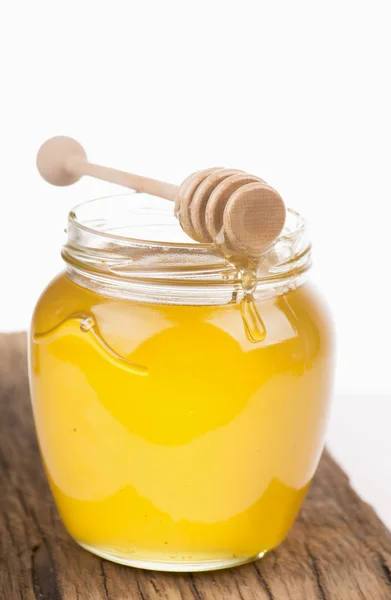 Honey in bank on wooden boards — Stock Photo, Image